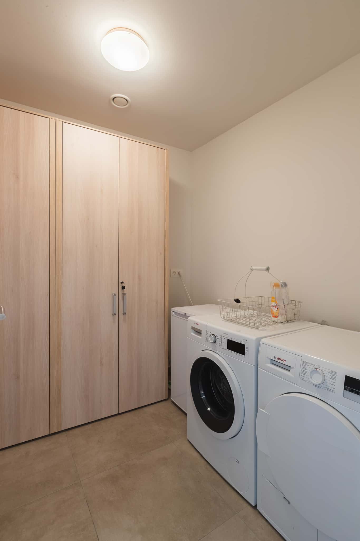 Wasruimte met wasmachine en droogkast in Le Bonheur de Louise