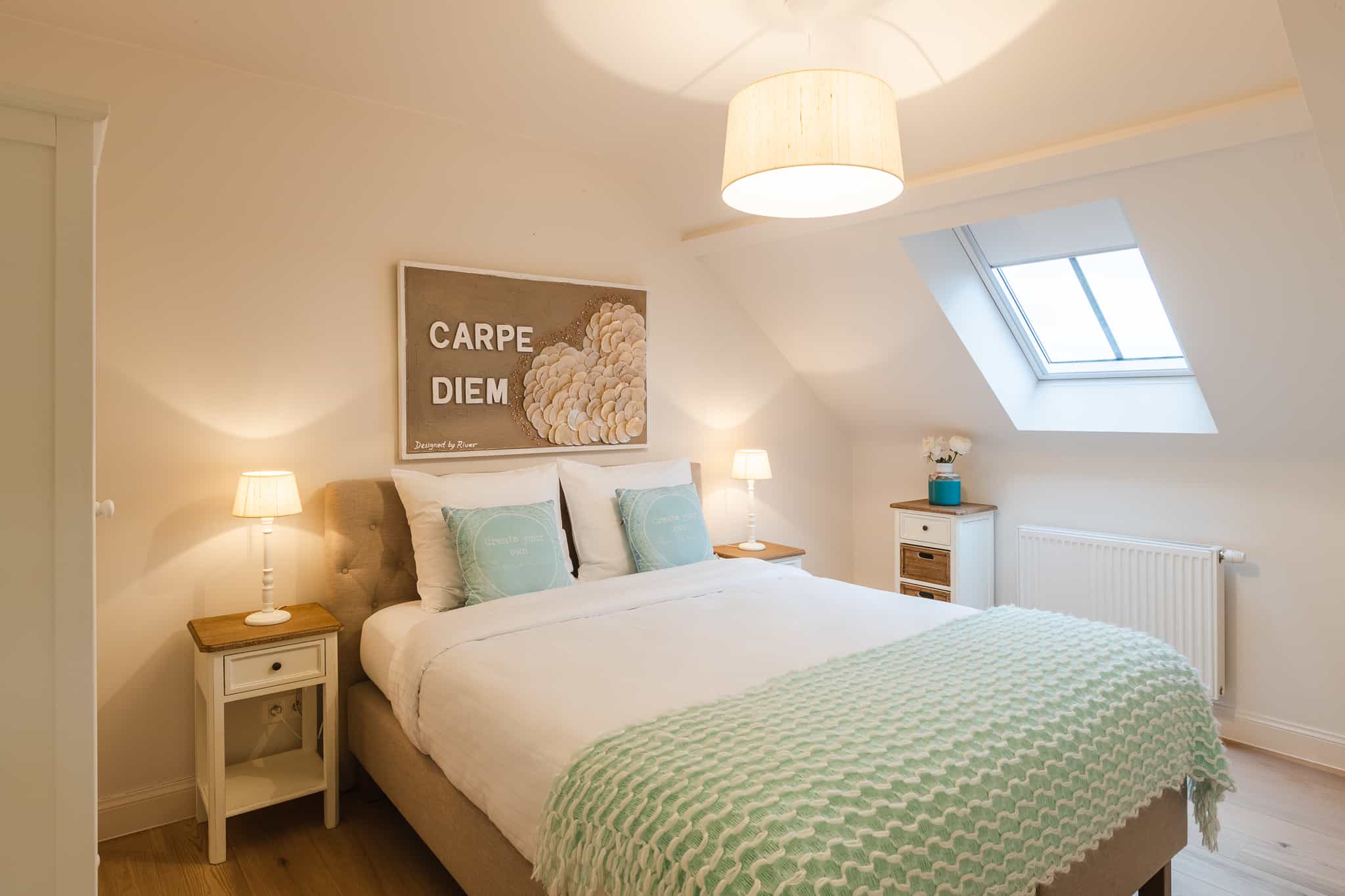 Tweepersoonsslaapkamer met dakraam en groen bedsprei in Le Bonheur de Louise