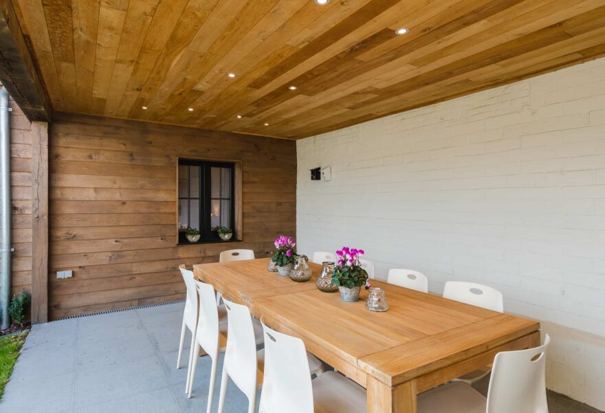 Overdekte patio met lange houten tafel in Le Bonheur de Louise