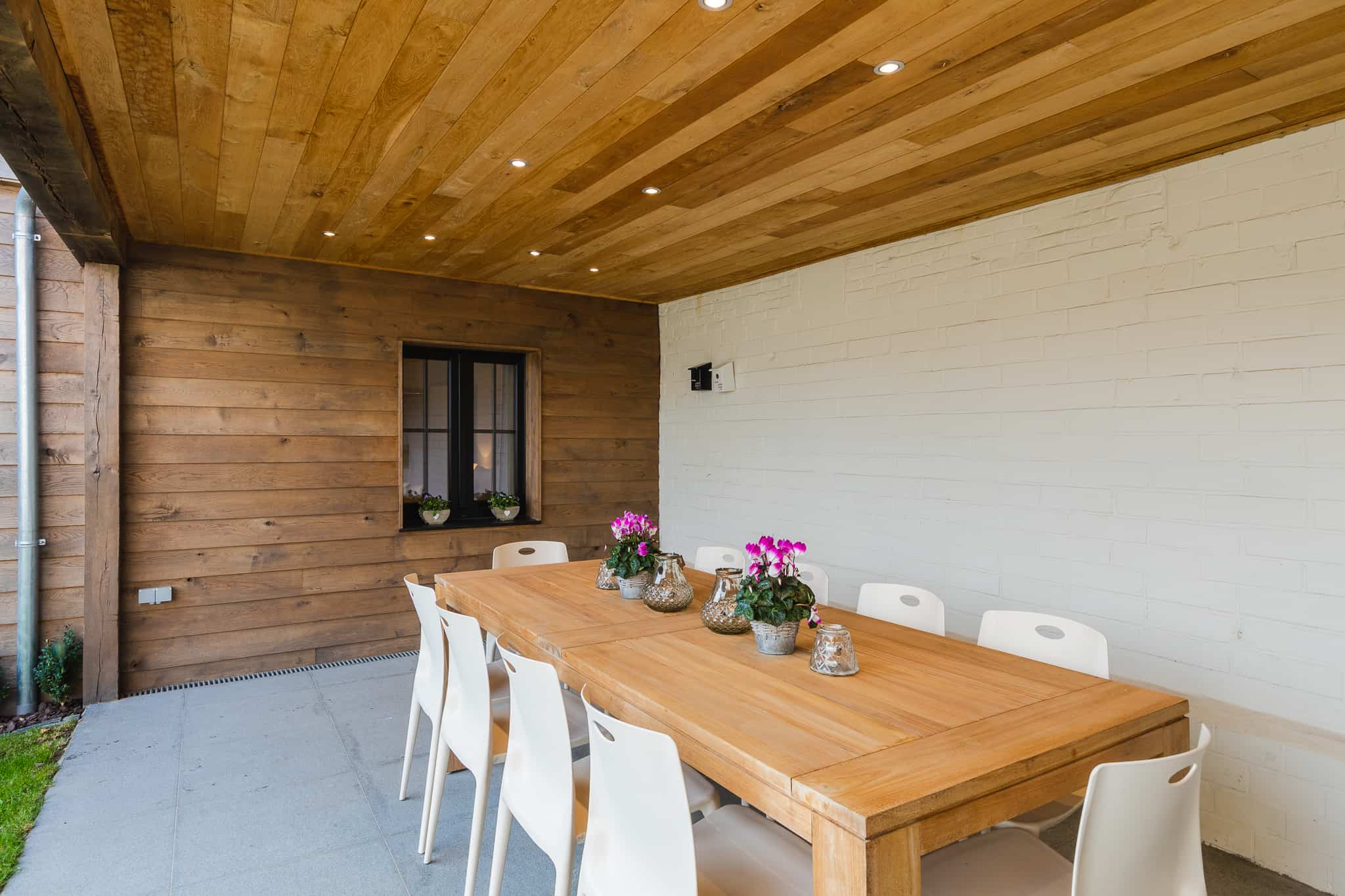 Overdekte patio met lange houten tafel in Le Bonheur de Louise