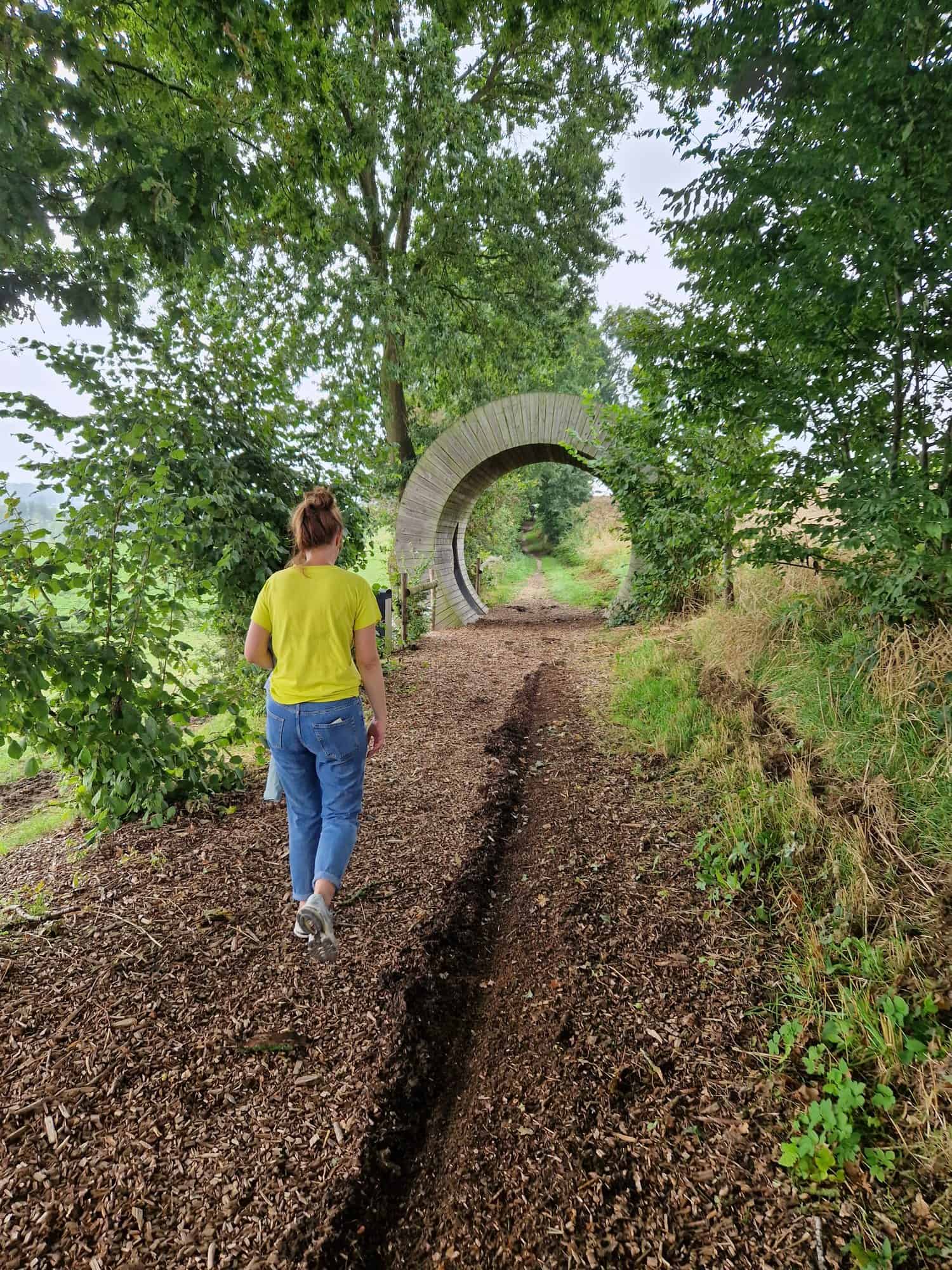 Wandelaarster op het pad naar de Deurnis, het ronde zitobject van de Z+-wandeling in Louise-Marie